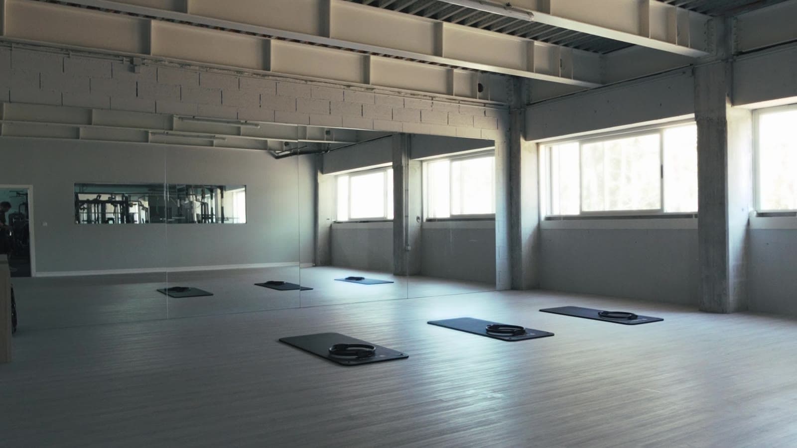 Sala de aulas de grupo do Connect Club, com colchões no chão, espelho e luz natural